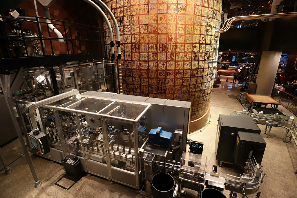 An image presenting automated industrial setup featuring advanced machinery and robotics in a modern manufacturing facility